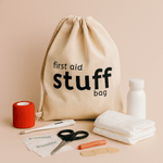 Natural 100% Cotton drawstring bag labeled 'first aid stuff bag' with first aid items on a beige background