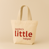 Natural tote bag with 'Santa's little helper' text on a beige background